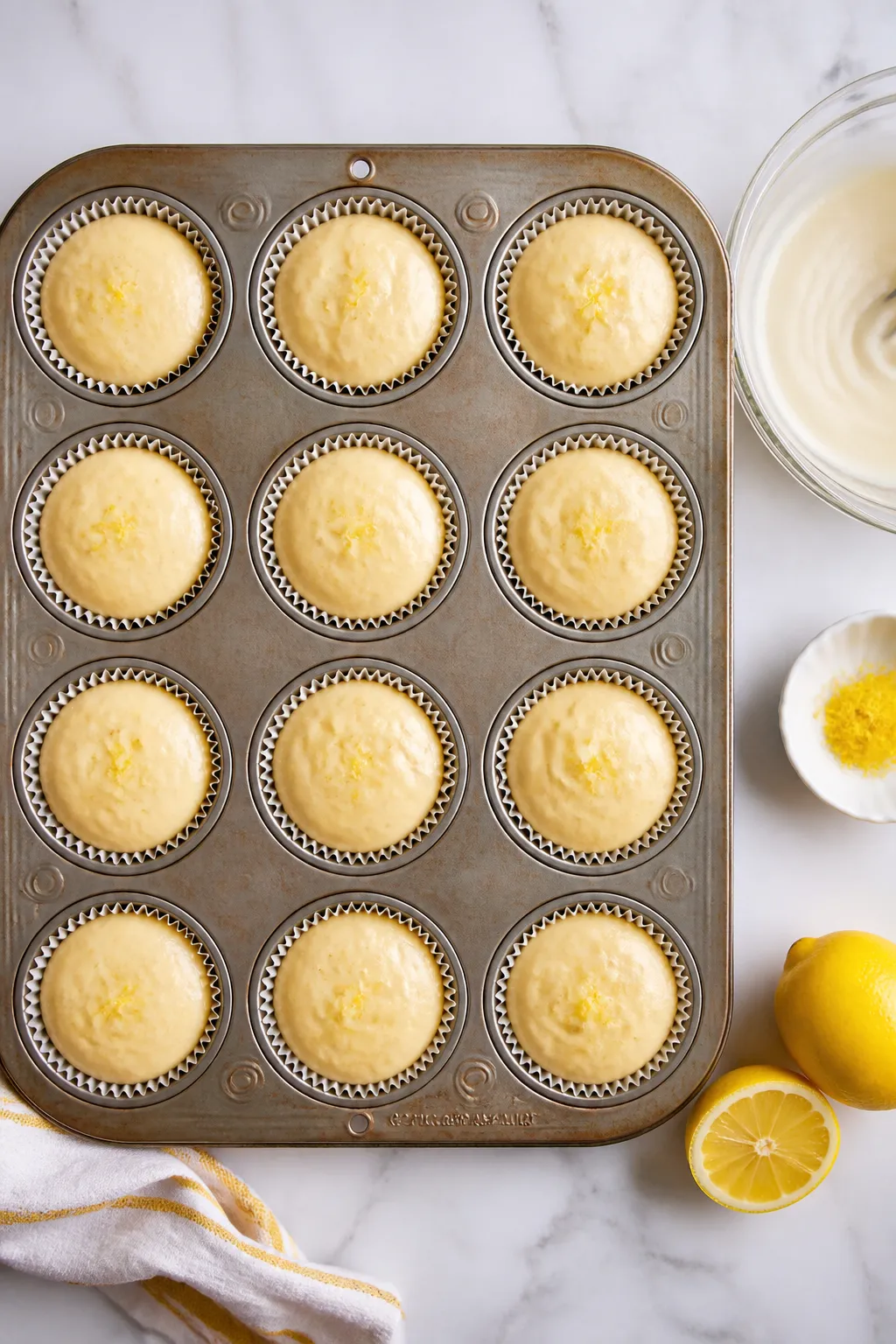Cooking process: Overhead shot of the batter being portioned into a lined 12-cup muffin tin, batter 