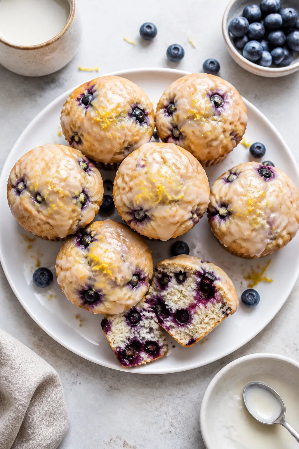 Final dish presentation: Restaurant-quality plate of vegan lemon blueberry muffins drizzled with a t
